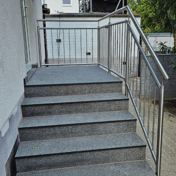 Moderne Außentreppe mit Edelstahlgeländer am Hauseingang